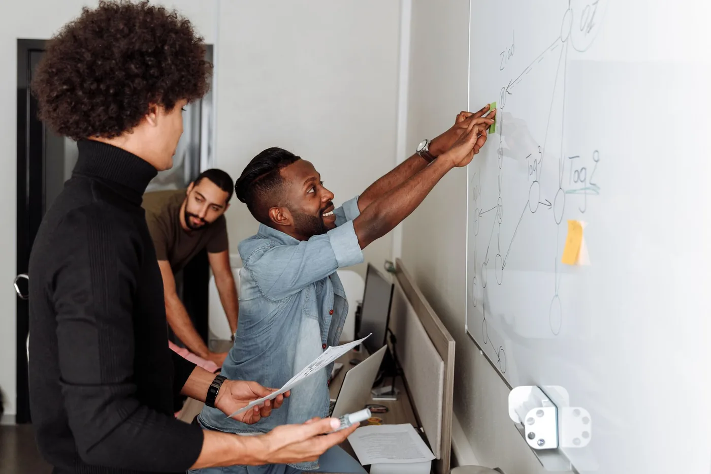 Tým startupu při brainstormingu u tabule